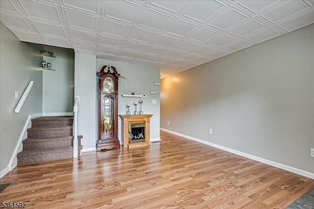 73-81 Mariners Ct, Plainfield City, NJ 07063 - unfurnished living room with stairway, light wood-style flooring, a fireplace, and an ornate ceiling