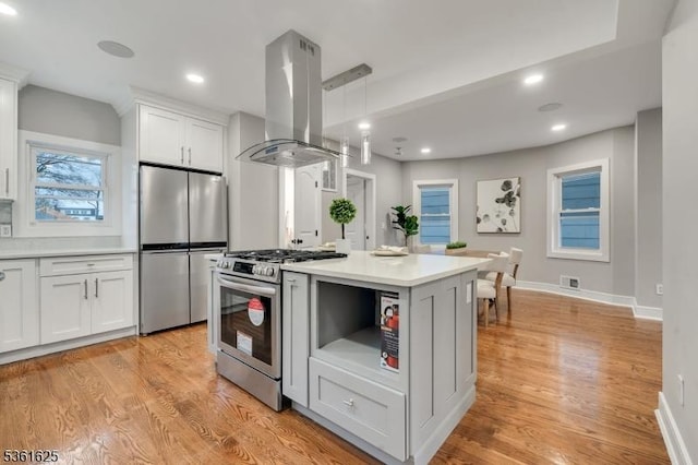 139 Weaver Ave, Bloomfield Twp, NJ 07003 - kitchen with appliances with stainless steel finishes, island range hood, white cabinetry, light countertops, and light wood-style flooring