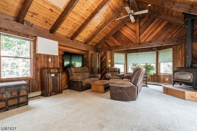 90 Libertyville Rd, Wantage Twp, NJ 07461 - carpeted living room featuring a wood stove, wood walls, wooden ceiling with exposed beams, a ceiling fan, and high vaulted ceiling
