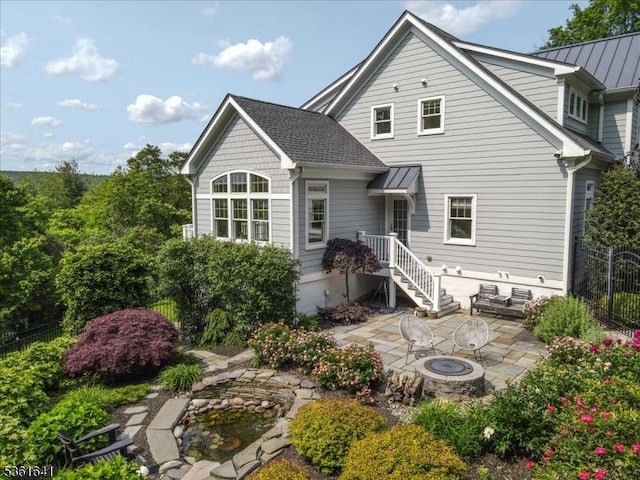 7 Shenandoah Ct, Washington Twp, NJ 07830 - back of property with an outdoor fire pit, a patio, a standing seam roof, and a metal roof