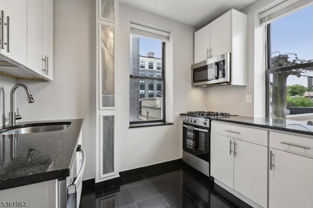 3315 Pleasant Ave Unit 314, Union City, NJ 07087 - kitchen with stainless steel appliances, a sink, white cabinetry, dark stone countertops, and baseboards