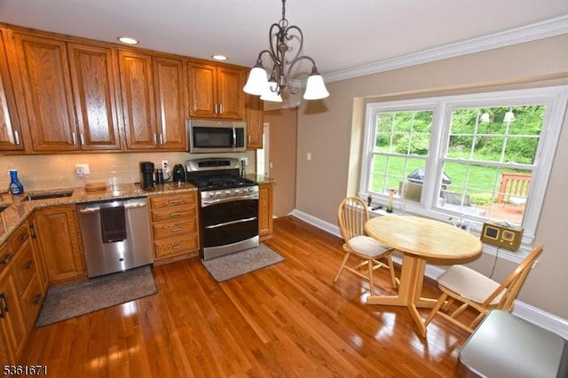 23 Pepperidge Rd, Morris Twp, NJ 07960 - kitchen featuring stainless steel appliances, brown cabinets, baseboards, wood finished floors, and ornamental molding