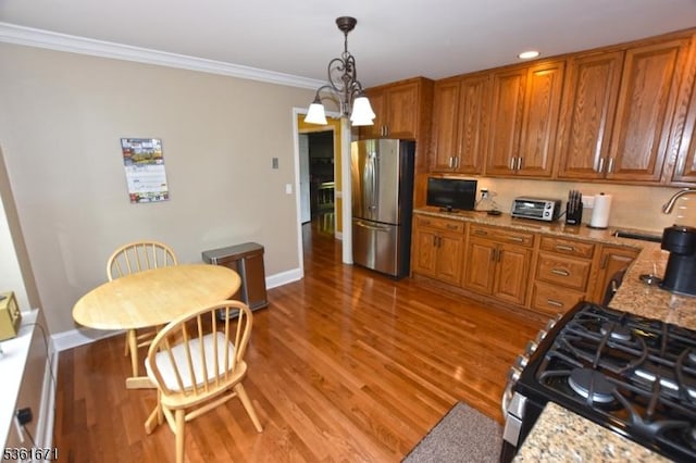 23 Pepperidge Rd, Morris Twp, NJ 07960 - kitchen featuring stainless steel appliances, brown cabinetry, light wood-style floors, light stone countertops, and hanging light fixtures