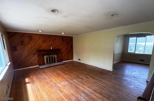 17 Hilltop Cir, Hanover Twp, NJ 07981 - unfurnished living room with arched walkways, crown molding, wood walls, baseboards, and wood finished floors