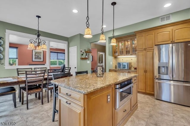11 Wesley Rd, Hillsborough Twp, NJ 08844 - kitchen featuring stainless steel appliances, a center island, light stone counters, glass insert cabinets, and hanging light fixtures
