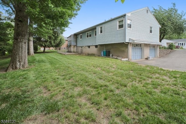 28 Stylon Rd, Wayne Twp, NJ 07470 - rear view of house featuring an attached garage, a yard, and driveway