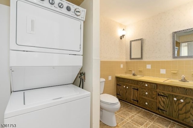 3 Bingham Ln, Blairstown Twp, NJ 07825 - bathroom with stacked washer and clothes dryer, double vanity, toilet, a wainscoted wall, and tile walls