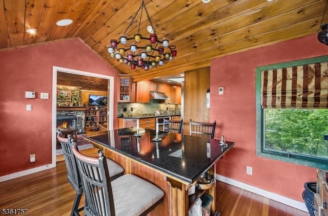 172 Alpine Trl, Sparta Twp, NJ 07871 - dining area featuring baseboards, vaulted ceiling, dark wood-style flooring, wood ceiling, and a fireplace