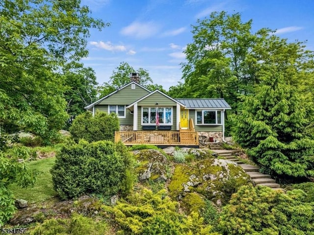 172 Alpine Trl, Sparta Twp, NJ 07871 - view of front of house featuring a chimney, stone siding, a deck, a standing seam roof, and metal roof