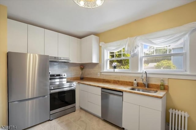 422 Valley Rd, Montclair Twp, NJ 07043 - kitchen with stainless steel appliances, radiator, under cabinet range hood, a sink, and light countertops