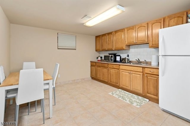 11 Putnam Ave, Berkeley Heights Twp, NJ 07922 - kitchen with freestanding refrigerator, a sink, stainless steel microwave, decorative backsplash, and light countertops