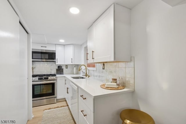121 3rd St, South Orange Village Twp, NJ 07079 - kitchen with stainless steel appliances, a sink, light countertops, decorative backsplash, and white cabinets