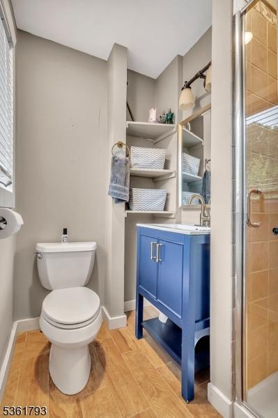 31 Center St, Netcong Boro, NJ 07857 - full bath featuring wood finished floors, baseboards, a shower stall, vanity, and toilet