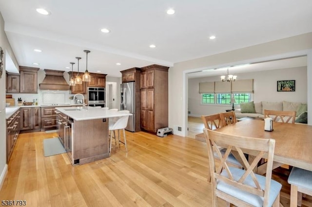 31 Center St, Netcong Boro, NJ 07857 - kitchen with stainless steel appliances, custom exhaust hood, a chandelier, light countertops, and a sink