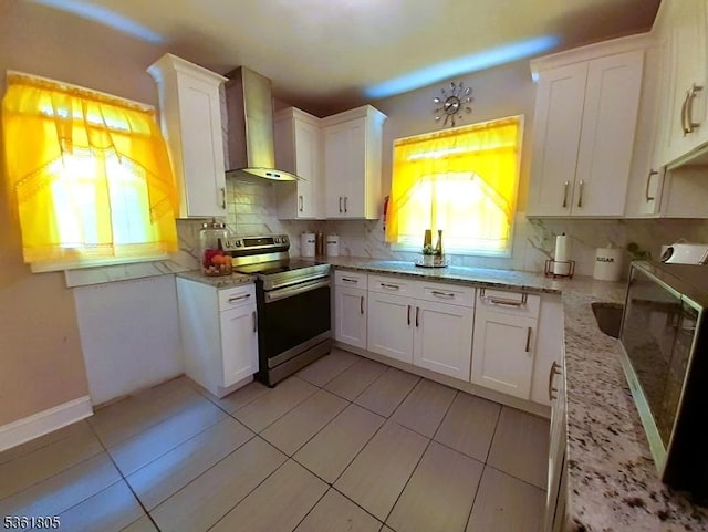 336 E 41st St, Paterson City, NJ 07504 - kitchen with wall chimney exhaust hood, stainless steel electric range, white cabinets, tasteful backsplash, and light stone counters