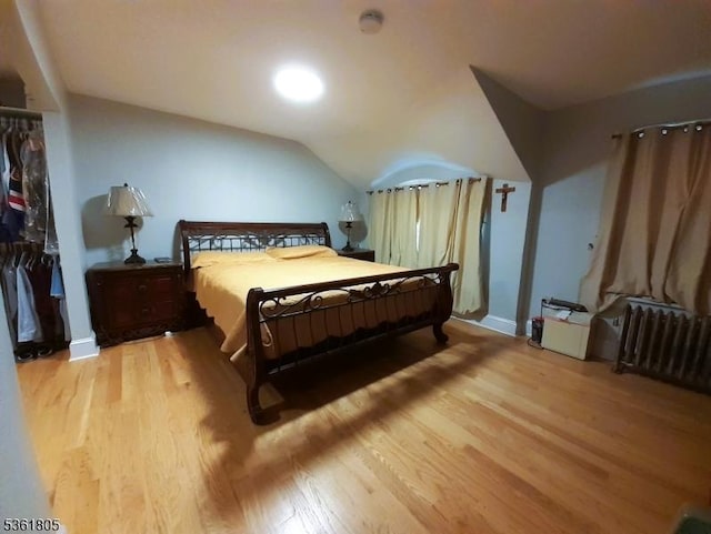 336 E 41st St, Paterson City, NJ 07504 - bedroom with light wood-style flooring, lofted ceiling, radiator heating unit, a closet, and baseboards