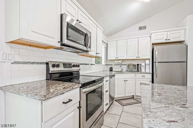 80 Cedar Tree Dr, Vernon Twp, NJ 07422 - kitchen featuring appliances with stainless steel finishes, lofted ceiling, white cabinetry, a sink, and backsplash
