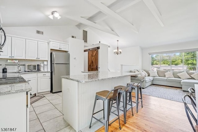 80 Cedar Tree Dr, Vernon Twp, NJ 07422 - kitchen featuring freestanding refrigerator, open floor plan, a kitchen bar, white cabinets, and a center island