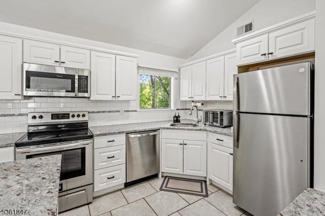 80 Cedar Tree Dr, Vernon Twp, NJ 07422 - kitchen with stainless steel appliances, a sink, lofted ceiling, backsplash, and white cabinets
