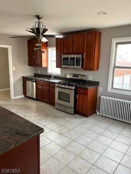 75 Laurel Ave, Union Twp, NJ 07083 - kitchen featuring appliances with stainless steel finishes, radiator heating unit, a sink, dark countertops, and ceiling fan