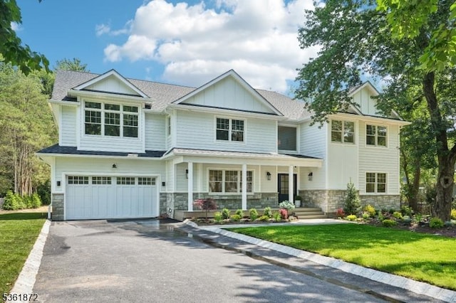 107 Rutland Rd, Glen Rock Boro, NJ 07452 - view of front of property with stone siding, an attached garage, driveway, covered porch, and board and batten siding