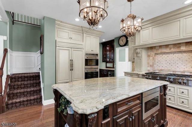 52 Independence Dr, Bernards Twp, NJ 07920 - kitchen featuring built in appliances, a chandelier, dark brown cabinets, light stone countertops, and backsplash