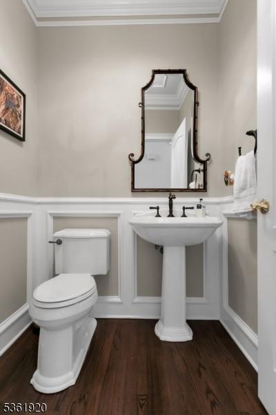 52 Independence Dr, Bernards Twp, NJ 07920 - bathroom featuring toilet, wainscoting, a decorative wall, crown molding, and wood finished floors