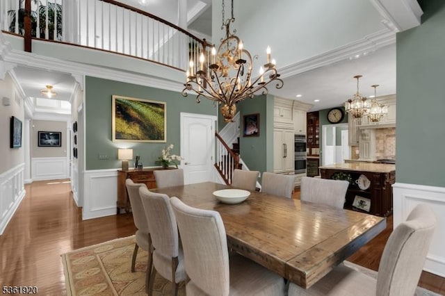 52 Independence Dr, Bernards Twp, NJ 07920 - dining area featuring wood finished floors, a chandelier, a decorative wall, stairs, and wainscoting