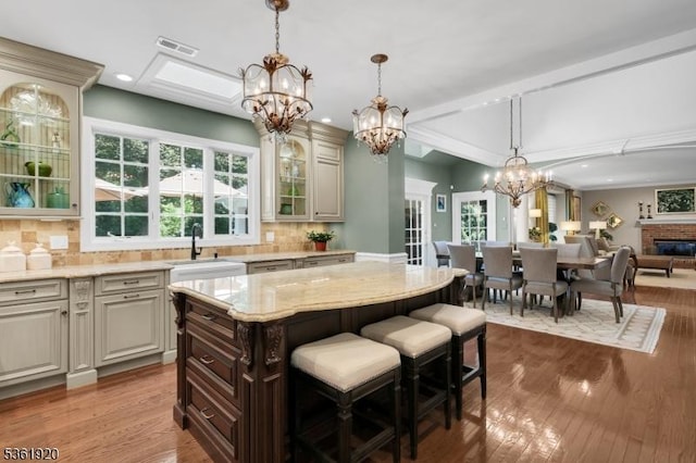 52 Independence Dr, Bernards Twp, NJ 07920 - kitchen with a chandelier, a sink, open floor plan, decorative backsplash, and light stone countertops