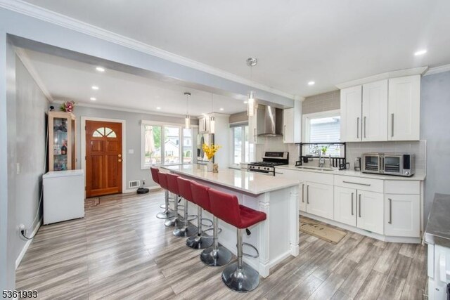 30 Filbert Ln, Union Twp, NJ 07083 - kitchen featuring stainless steel gas range oven, wall chimney range hood, a sink, light wood-style floors, and light countertops