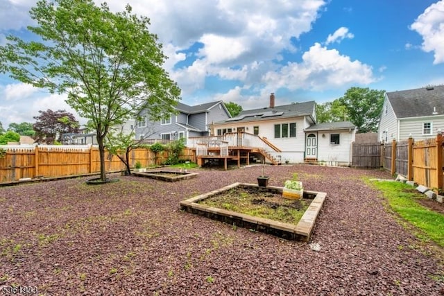 30 Filbert Ln, Union Twp, NJ 07083 - back of property with a vegetable garden, a deck, and a fenced backyard