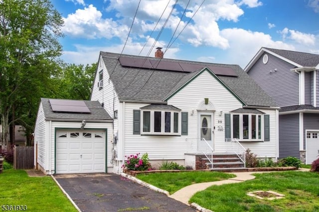 30 Filbert Ln, Union Twp, NJ 07083 - view of front of house with solar panels, an attached garage, a chimney, driveway, and roof with shingles