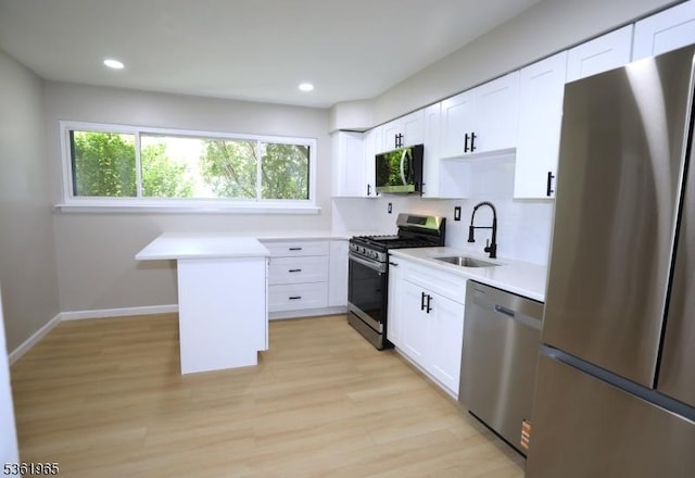 914 Merritt Dr Unit E, Hillsborough Twp, NJ 08844 - kitchen featuring stainless steel appliances, a sink, light countertops, light wood finished floors, and white cabinetry