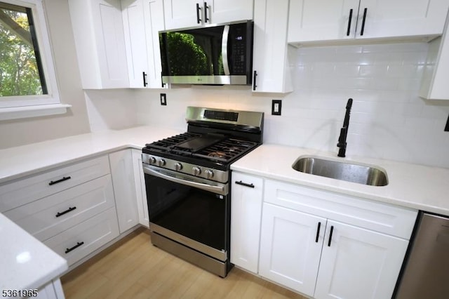 914 Merritt Dr Unit E, Hillsborough Twp, NJ 08844 - kitchen with appliances with stainless steel finishes, a sink, white cabinetry, backsplash, and light countertops