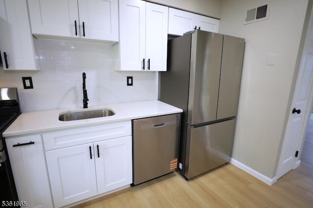 914 Merritt Dr Unit E, Hillsborough Twp, NJ 08844 - kitchen featuring appliances with stainless steel finishes, a sink, light wood-type flooring, and white cabinets