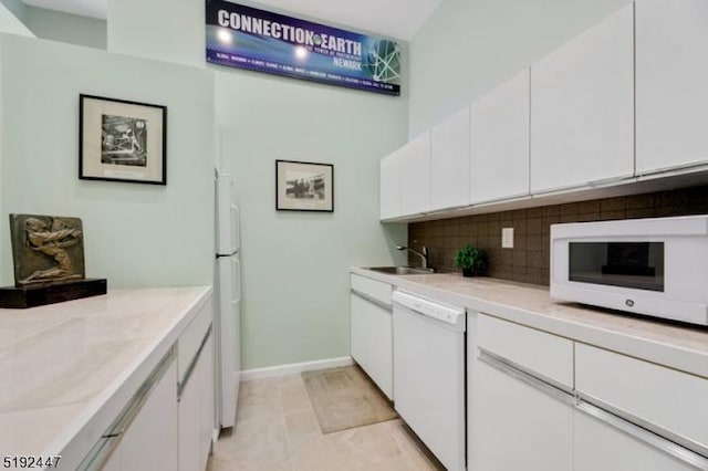 111 Mulberry St Unit Sky, Newark City, NJ 07102 - kitchen featuring white appliances, a sink, decorative backsplash, white cabinets, and light countertops