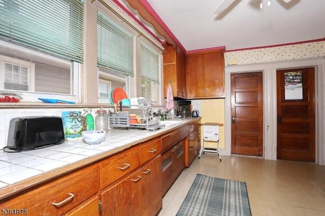 267 Hoover Ave, Bloomfield Twp, NJ 07003 - kitchen featuring tile counters, brown cabinets, ceiling fan, and light tile patterned floors