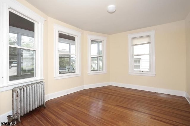 267 Hoover Ave, Bloomfield Twp, NJ 07003 - spare room featuring radiator heating unit, healthy amount of natural light, dark wood-type flooring, and baseboards