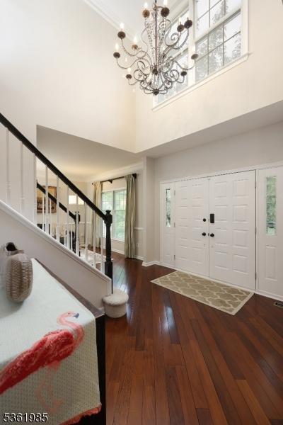 7 Watchung Dr, Bernards Twp, NJ 07920 - entrance foyer featuring a towering ceiling, a chandelier, stairs, hardwood / wood-style flooring, and baseboards