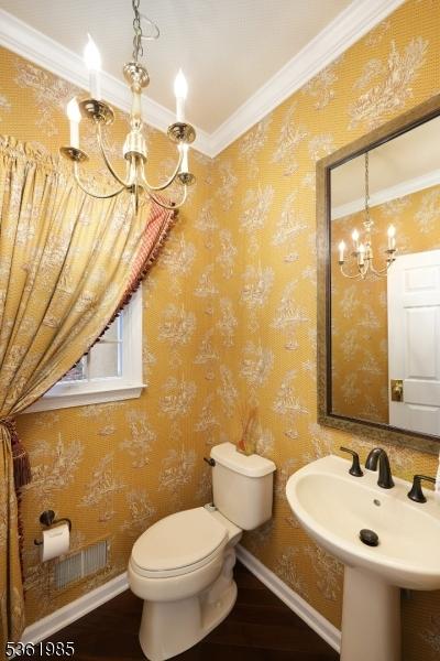 7 Watchung Dr, Bernards Twp, NJ 07920 - half bath featuring a chandelier, toilet, ornamental molding, wood finished floors, and a sink