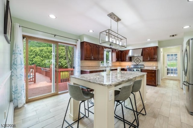 5 Mariner Dr, Randolph Twp, NJ 07869 - kitchen featuring wall chimney range hood, freestanding refrigerator, range, a breakfast bar, and a kitchen island