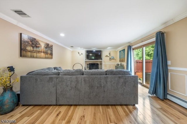 5 Mariner Dr, Randolph Twp, NJ 07869 - living area with ornamental molding, light wood finished floors, a baseboard radiator, a brick fireplace, and recessed lighting