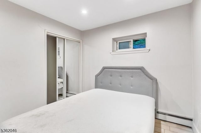 2200 Paterson Plank Rd Unit 23, North Bergen Twp, NJ 07047 - bedroom featuring a baseboard heating unit, light wood-style flooring, a closet, baseboard heating, and recessed lighting