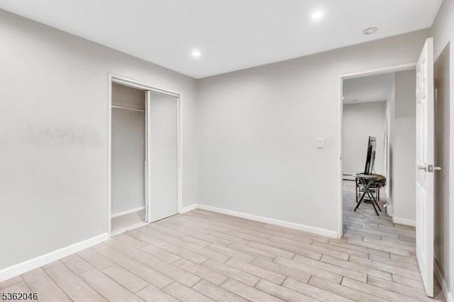 2200 Paterson Plank Rd Unit 23, North Bergen Twp, NJ 07047 - unfurnished bedroom with light wood-style floors, recessed lighting, baseboards, a closet, and a baseboard heating unit