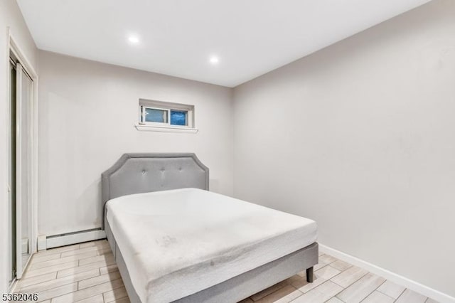 2200 Paterson Plank Rd Unit 23, North Bergen Twp, NJ 07047 - bedroom featuring wood finish floors, recessed lighting, a closet, a baseboard heating unit, and baseboards