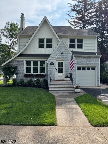 701 High St, Cranford Twp, NJ 07016 - view of front of home featuring a front yard, a garage, a chimney, board and batten siding, and driveway