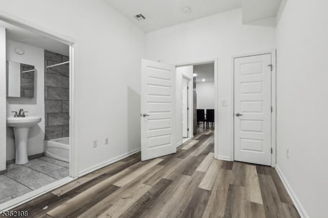 430 Ocean Ave, Jersey City, NJ 07305 - unfurnished bedroom featuring wood finished floors, baseboards, ensuite bath, and a sink