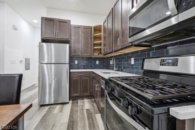 430 Ocean Ave, Jersey City, NJ 07305 - kitchen featuring stainless steel appliances, a sink, dark brown cabinets, open shelves, and light wood finished floors