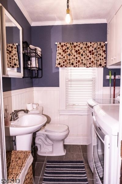 24 Ryerson Ave, Newton Town, NJ 07860 - bathroom featuring washer and clothes dryer, tile patterned floors, toilet, a wainscoted wall, and crown molding