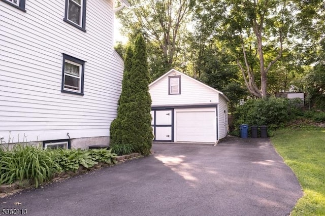 24 Ryerson Ave, Newton Town, NJ 07860 - detached garage with asphalt driveway and view of wooded area